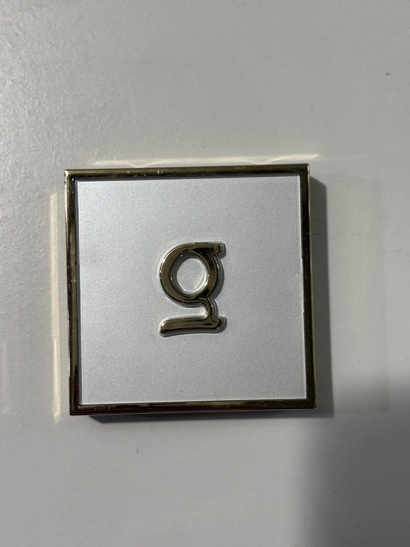 Gold and White Monogram Compact Mirror (Category: Mirrors) located in San Fernando. Submitted by koalashelves (Listing ID 1470173391, Image 1). Description: - Elegant square compact mirror with a shiny gold finish - Stylish white top lid accented with a raised silver letter 'g' - Features a built-in mirror for easy makeup application - Compact and lightweight size - Perfect for your handbag, pouch, or everyday on-the-go touch-ups.