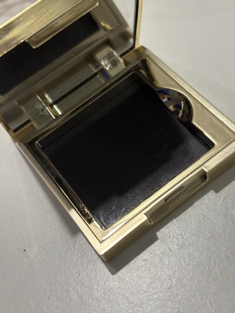 Gold and White Monogram Compact Mirror (Category: Mirrors) located in San Fernando. Submitted by koalashelves (Listing ID 1470173391, Image 2). Description: - Elegant square compact mirror with a shiny gold finish - Stylish white top lid accented with a raised silver letter 'g' - Features a built-in mirror for easy makeup application - Compact and lightweight size - Perfect for your handbag, pouch, or everyday on-the-go touch-ups.