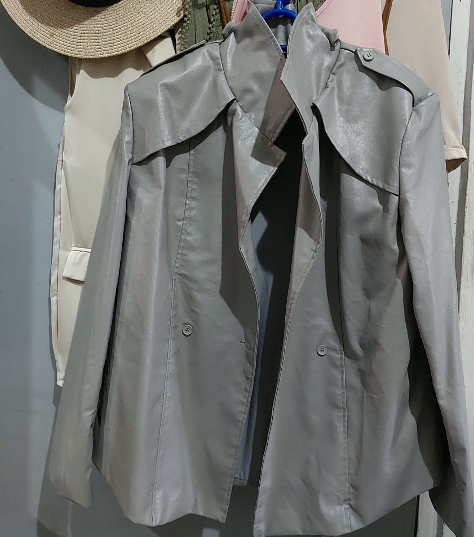 Gosmina Grey Faux Leather Trench Jacket Coat (Category: Coats, Jackets and Outerwear) located in Taguig. Submitted by hhhcherish (Listing ID 1470194708, Image 1). Description: - Brand: Gosmina - Style: Faux leather trench jacket in grey - Closure: Double-breasted front with buttons - Features: Lapel collar, shoulder epaulettes, and back storm flap - Interior: Smooth lining for comfortable layering - Perfect for: Cool weather layering UK Brand sup