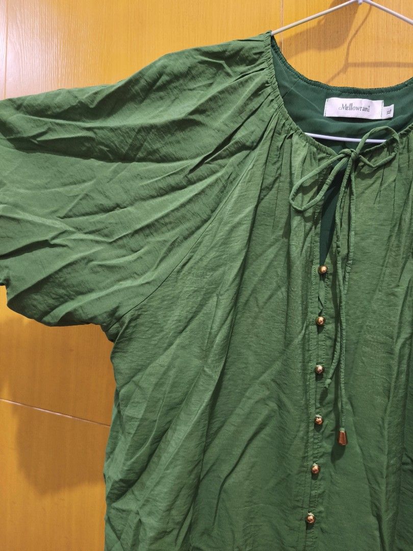 Green Puff Sleeve Blouse Size XL (Category: Blouses) located in Taguig. Submitted by deyerreC2020 (Listing ID 1470280644, Image 3). Description: premium blouse bust 46 Brand: Mellowrani - Size: XL - Color: Green - Fit: Loose fit with puff sleeves - Neckline: High neck with tie string detail - Closure: Front placket with small gold-toned buttons down - Material: polyester fabric - Condition: Brand new / Excellent (ready to wear) - Perfect for dail