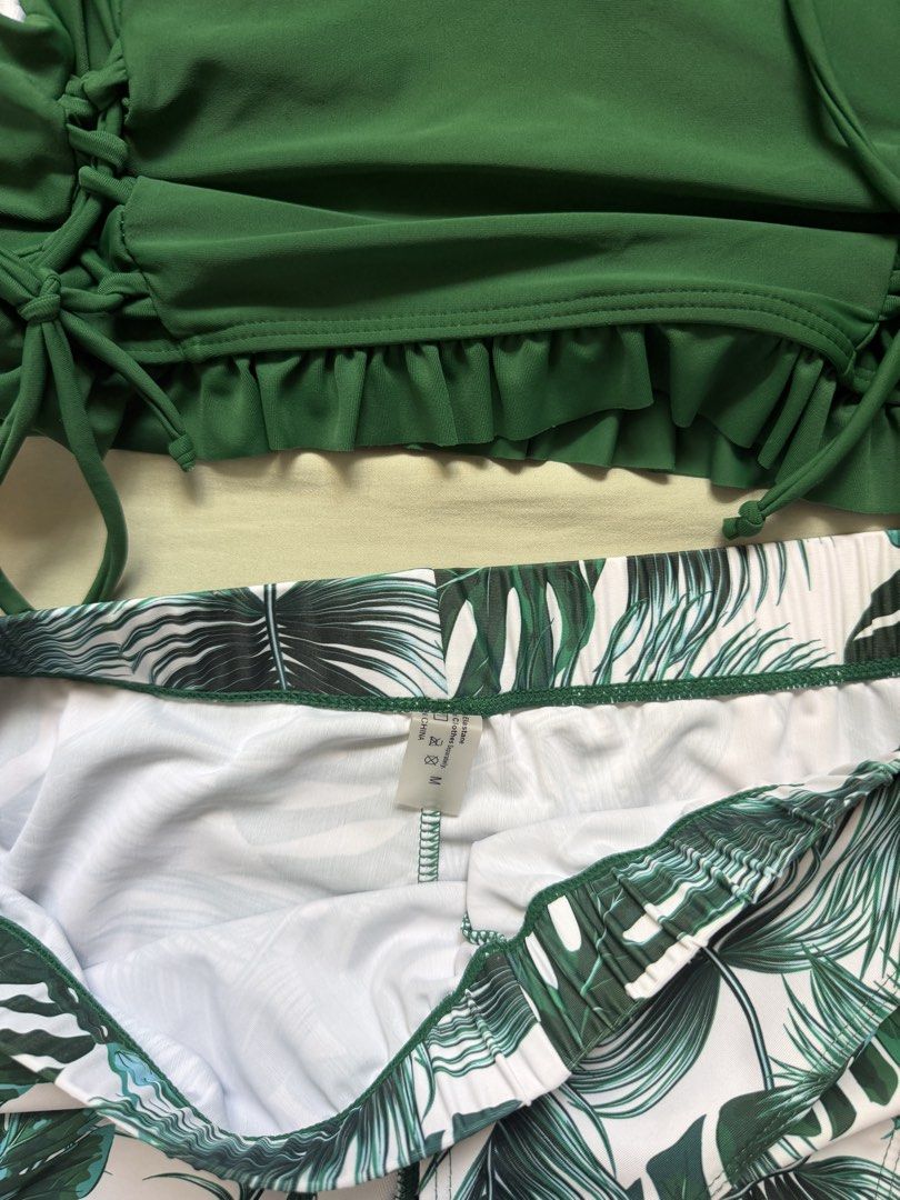 Green Tropical Palm Print Bikini Set Size M (Category: Bikinis & Swimsuits) located in Dinalupihan. Submitted by wonmeoww (Listing ID 1470252412, Image 2). Description: - 3-piece tropical swimwear set - Solid dark green bikini top with side ties and cute ruffled hem - Matching tropical leaf print bikini bottoms - Includes white and green leaf print boardshorts - Size: Medium.