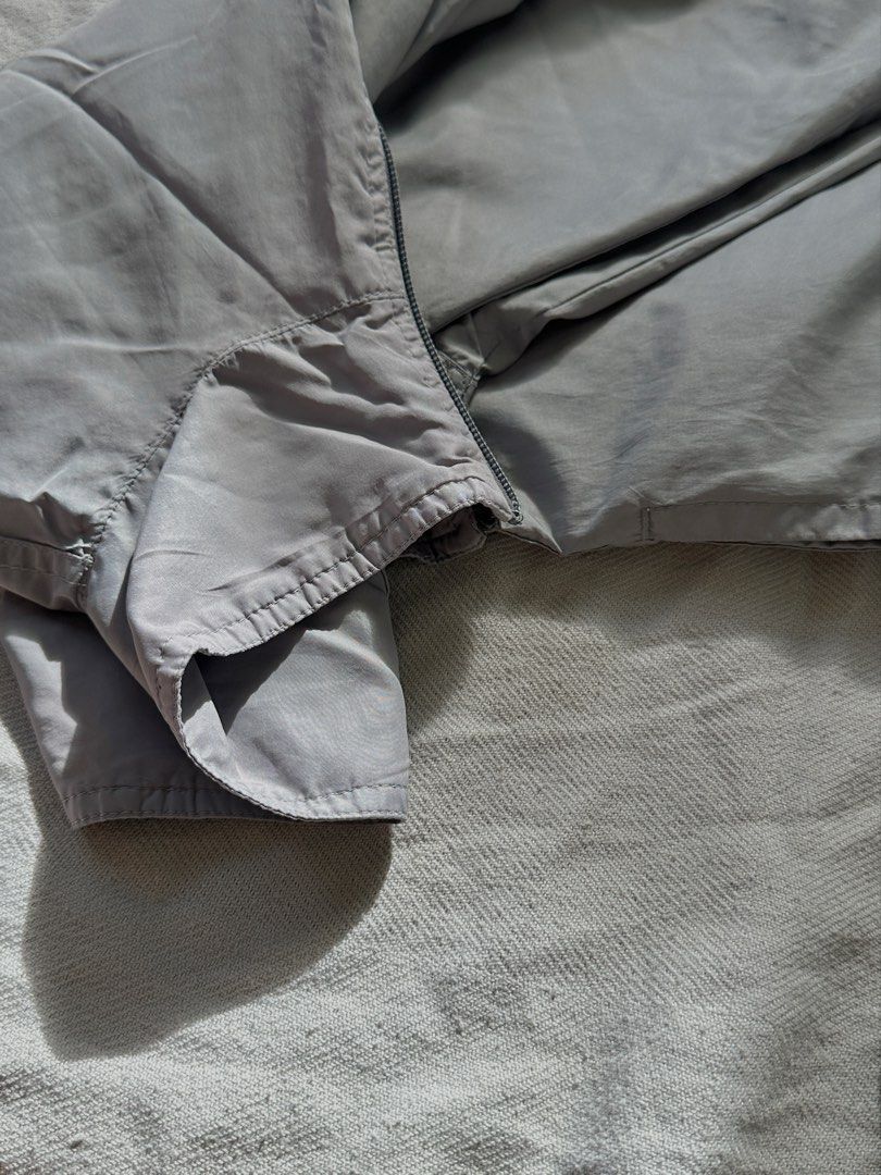 Grey Zip Up Windbreaker Jacket (Category: Coats, Jackets and Outerwear) located in Lipa City. Submitted by collbyisidora (Listing ID 1470308189, Image 2). Description: - Issue: Zipper Pull Tab needs replacement - Color: Light grey - Material: Lightweight, clean fabric - Design: Full front zipper with high collar - Fit: Long sleeves with ribbed cuffs and adjustable drawstring hem - Styling: Easy to throw on over any t-shirt.