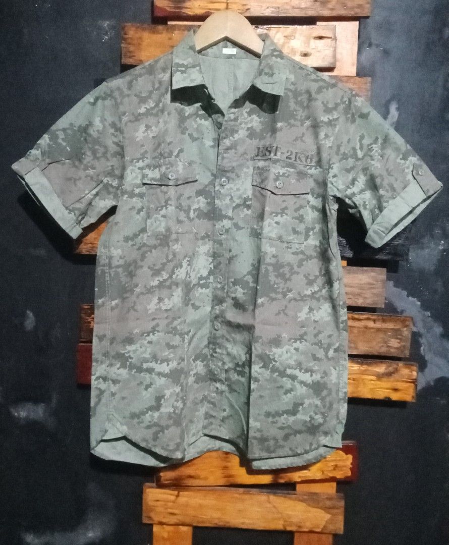 GU Camouflage Short Sleeve Button Up Shirt (Category: Tshirts & Polo Shirts ) located in Caloocan City. Submitted by calmcat_6fd4f7 (Listing ID 1470345357, Image 3). Description: - Brand/Style: GU camouflage short sleeve shirt in green tones - Material: 100% breathable cotton - Size: Tagged M (Width: 20", Length: 27", Arm: 9") - Details: Button-up front, dual chest pockets, and printed text above the left pocket - Condition: Clean, well-maintaine