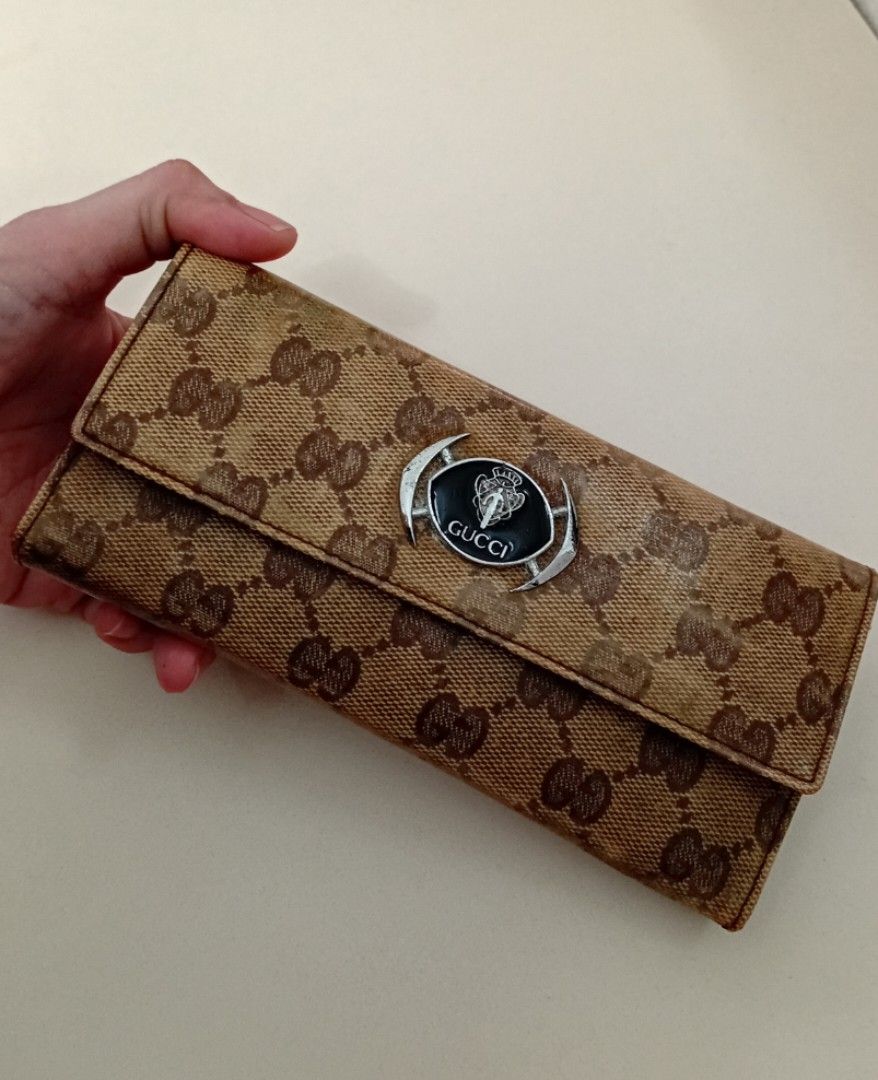 Gu cci Monogram long wallet with crest clasp (Category: Luxury Bags & Wallets) located in Manila. Submitted by eriiicaspage (Listing ID 1470278247, Image 1). Description: PreOwned WellUsed Gucci monogram long wallet in classic beige and brown canvas - Luxurious brown leather interior with multiple card slots and cash compartments - Secure snap button closure with silver-toned hardware and black enamel Gucci crest logo centerpiece - Classic trifol