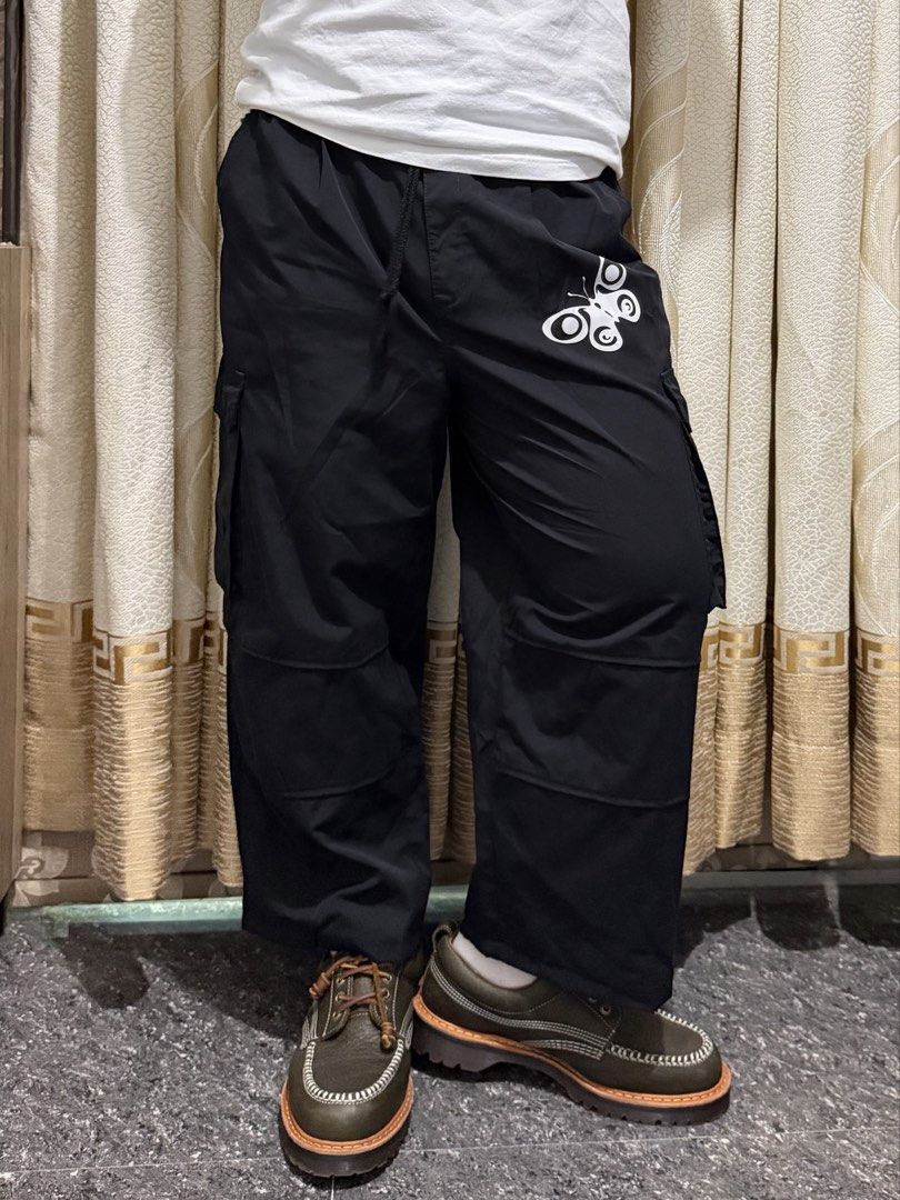 GU Personalized Black Butterfly Skull Cargo Pants Size L (Category: Joggers) located in Guiguinto. Submitted by aries_ji (Listing ID 1470254514, Image 3). Description: - Brand: GU - Size: L - Color: Black with striking white butterfly and skull graphics - Fit: Relaxed, wide-leg silhouette with elastic waistband - Material: 67% polyester, 33% cotton blend - Features: Multiple utility pockets for high functionality - Style: Trendy streetwear piece,