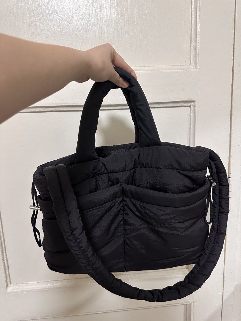 GU Puff Drawstring Bag (Black) (Category: Tote Bags) located in Quezon City. Submitted by monique29_ (Listing ID 1470215647, Image 1). Description: - Color: Black - Material: Lightweight nylon with quilted texture - Versatile wear: Soft padded handles and adjustable long strap for shoulder or crossbody use - Closure: Secure snap button main compartment - Storage: Roomy interior with smaller slip pockets for organization - Exterior: Two handy fron