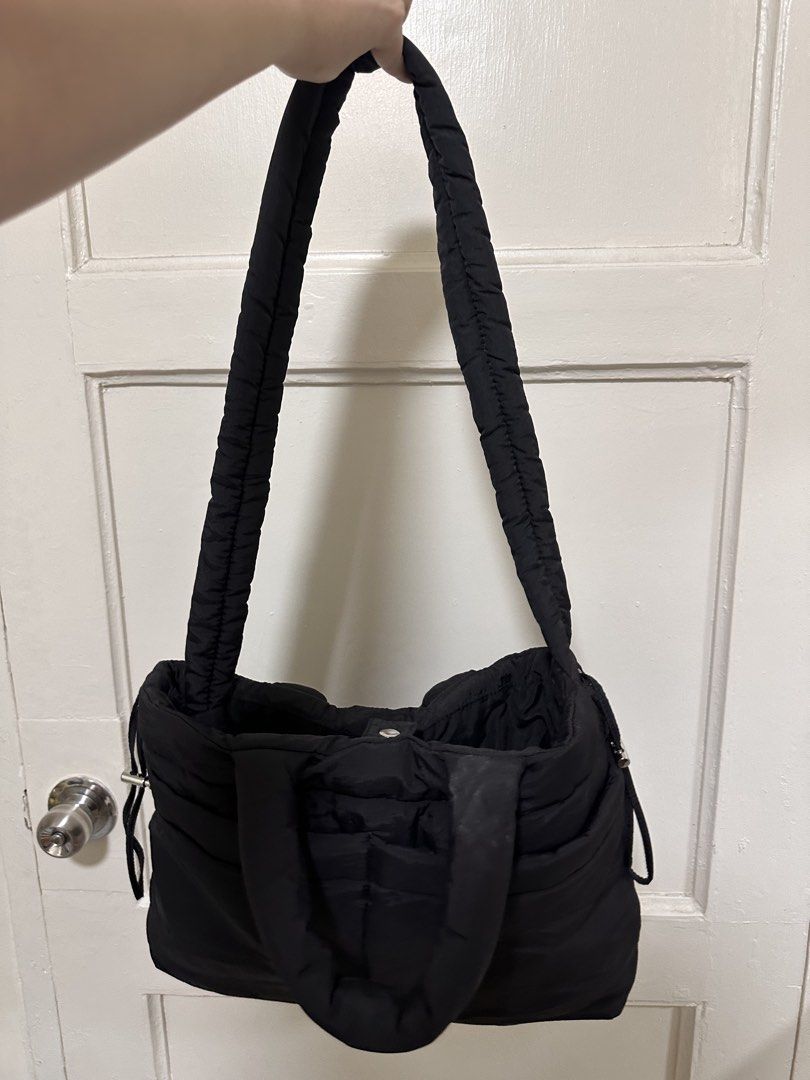GU Puff Drawstring Bag (Black) (Category: Tote Bags) located in Quezon City. Submitted by monique29_ (Listing ID 1470215647, Image 2). Description: - Color: Black - Material: Lightweight nylon with quilted texture - Versatile wear: Soft padded handles and adjustable long strap for shoulder or crossbody use - Closure: Secure snap button main compartment - Storage: Roomy interior with smaller slip pockets for organization - Exterior: Two handy fron
