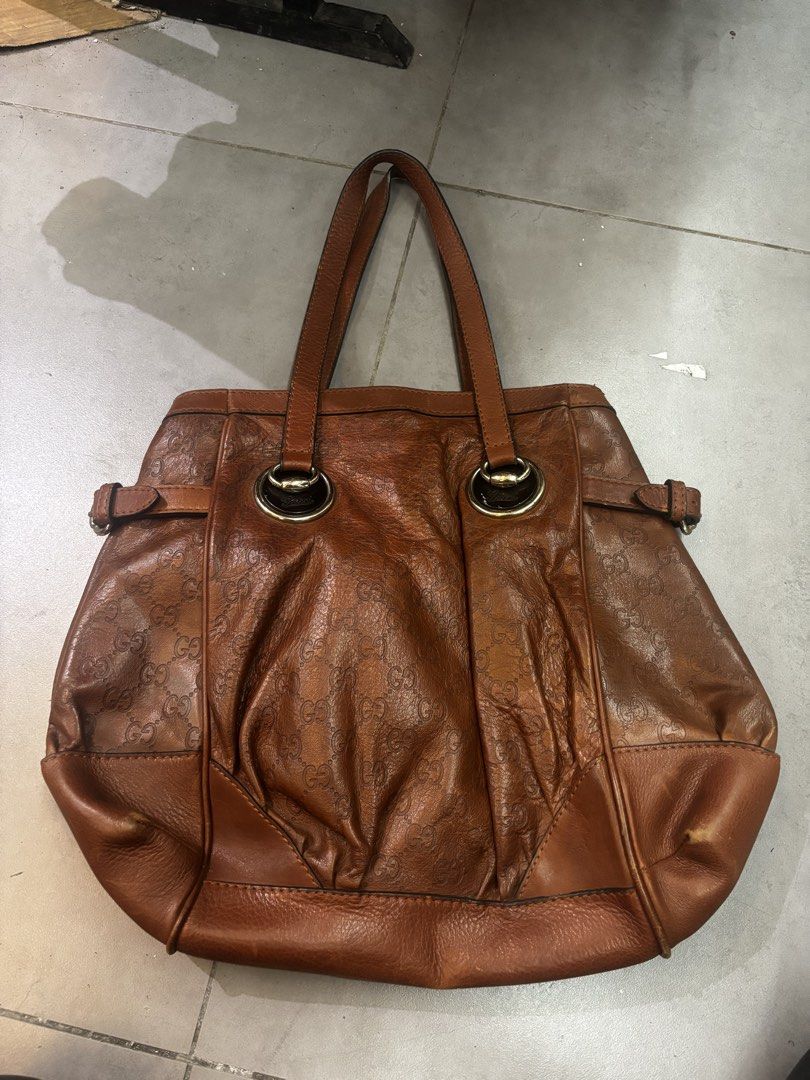 Gucci Brown Leather Tote Bag GG Monogram (Category: Luxury Bags & Wallets) located in Caloocan City. Submitted by neweagle-424b (Listing ID 1470191578, Image 1). Description: - Brand: Gucci - Material: Premium Brown Leather with debossed GG monogram pattern - Hardware: Silver-tone metal rings with engraved script logo and side buckle accents - Closure: Zip top with branded zipper pull - Interior: Patterned fabric lining with authentic 'Gucci made