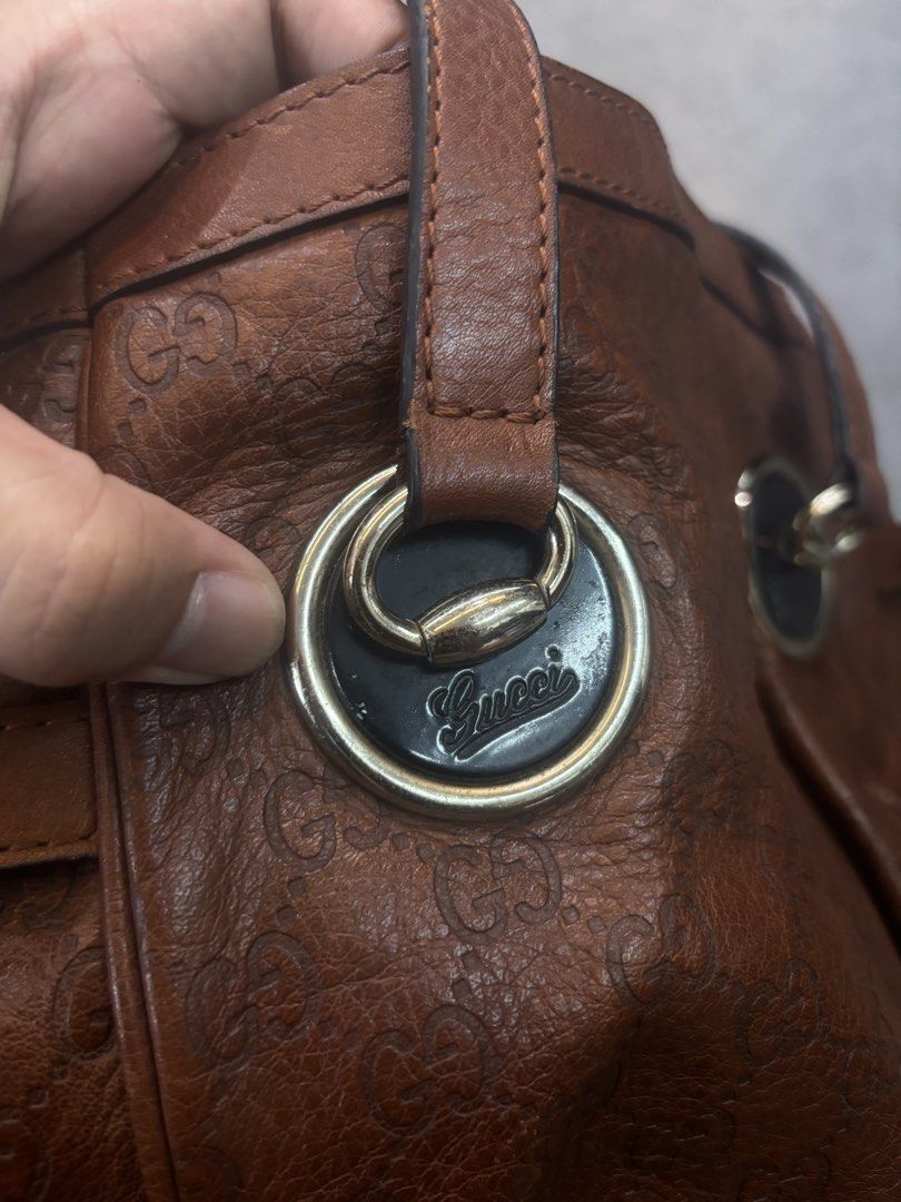 Gucci Brown Leather Tote Bag GG Monogram (Category: Luxury Bags & Wallets) located in Caloocan City. Submitted by neweagle-424b (Listing ID 1470191578, Image 2). Description: - Brand: Gucci - Material: Premium Brown Leather with debossed GG monogram pattern - Hardware: Silver-tone metal rings with engraved script logo and side buckle accents - Closure: Zip top with branded zipper pull - Interior: Patterned fabric lining with authentic 'Gucci made