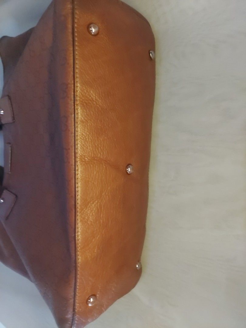 Gucci Brown Monogram Leather Tote Bag (Category: Luxury Bags & Wallets) located in Quezon City. Submitted by never_a_clutter (Listing ID 1470166565, Image 3). Description: - Authentic brown leather Gucci tote bag - All-over debossed GG monogram pattern - Durable dark brown fabric shoulder straps with leather attachment patches - Secure top zip closure (jacket type zipper) - Dark fabric interior lining - 1 interior zippered pocket and smaller slip