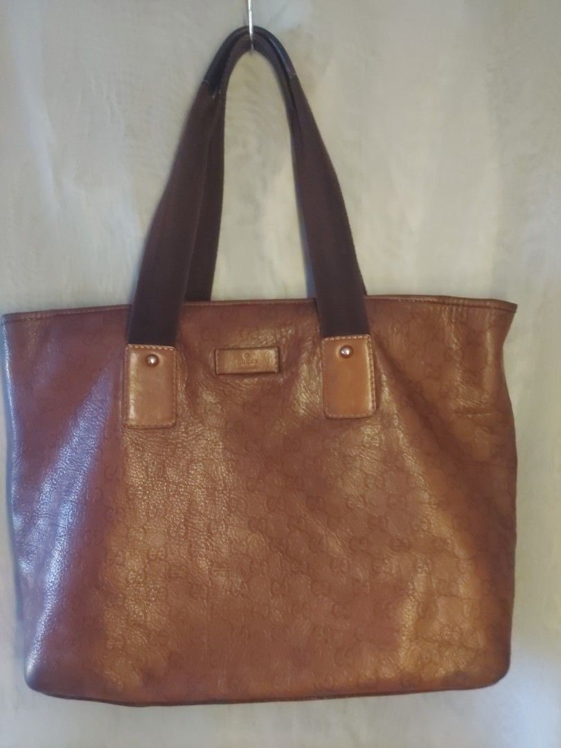 Gucci Brown Monogram Leather Tote Bag (Category: Luxury Bags & Wallets) located in Quezon City. Submitted by never_a_clutter (Listing ID 1470166565, Image 1). Description: - Authentic brown leather Gucci tote bag - All-over debossed GG monogram pattern - Durable dark brown fabric shoulder straps with leather attachment patches - Secure top zip closure (jacket type zipper) - Dark fabric interior lining - 1 interior zippered pocket and smaller slip