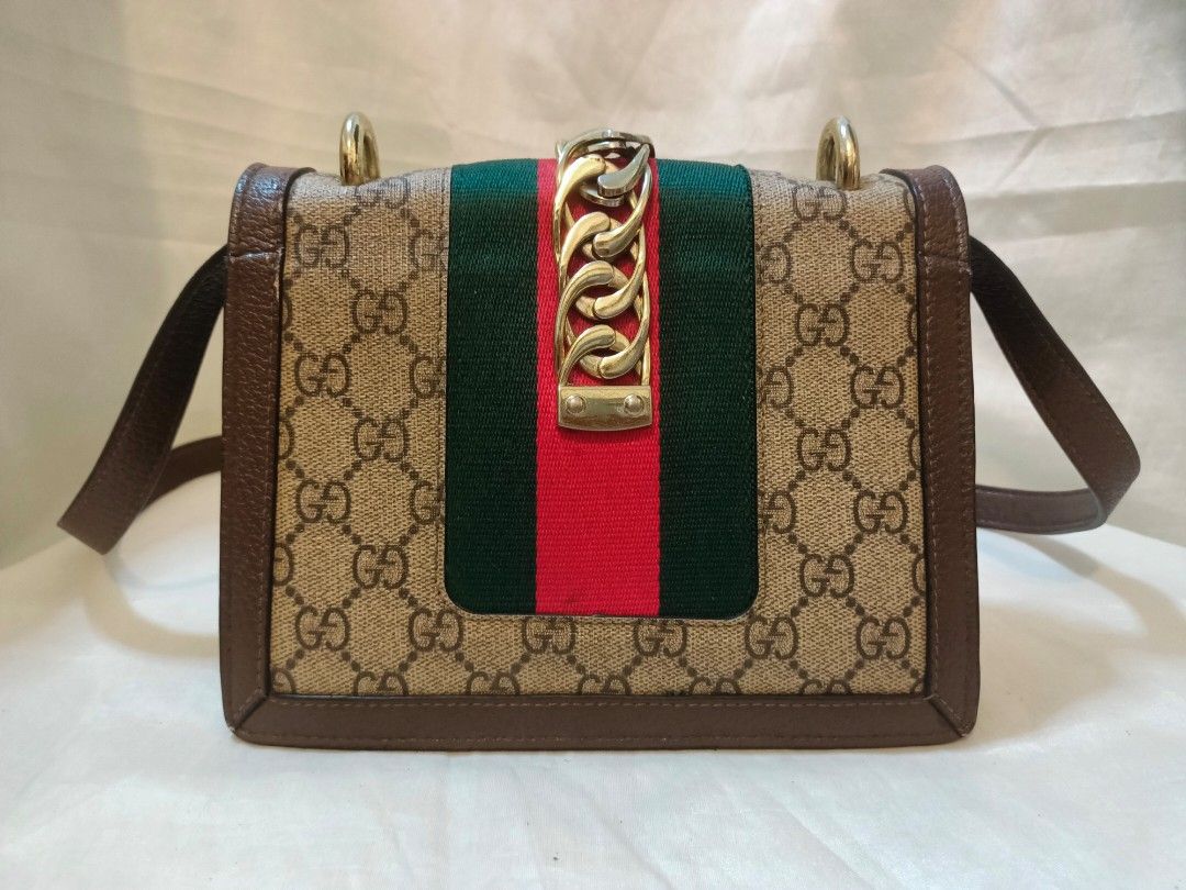 Gucci GG Supreme Sylvie Shoulder Bag (Category: Shoulder Bags) located in Manila. Submitted by minesviewstuffs (Listing ID 1466384172, Image 3). Description: - Gucci Sylvie Shoulder Bag - Material: GG Supreme canvas with premium brown leather trim - Design: Iconic green and red web stripe with gold-tone chain buckle closure - Versatile: Includes a sturdy top handle and an adjustable leather crossbody strap - Shape: Elegant structured rectangular 