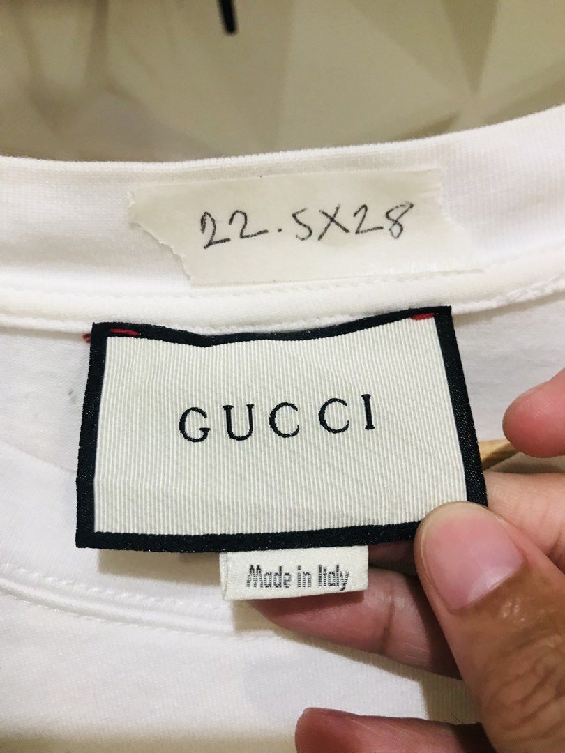 Gucci Vintage Logo Tee White (Category: Luxury Apparel) located in Manila. Submitted by luxurybrandedthrift05 (Listing ID 1470215312, Image 2). Description: - Authentic Gucci cotton t-shirt in white - Features distressed logo graphic across the chest - Classic red and green web stripe with interlocking GG logo - Made in Italy tag at the collar - Measurements: 22.5 inches (pit to pit) by 28 inches (length) - Short sleeves with ribbed crewneck - Cl