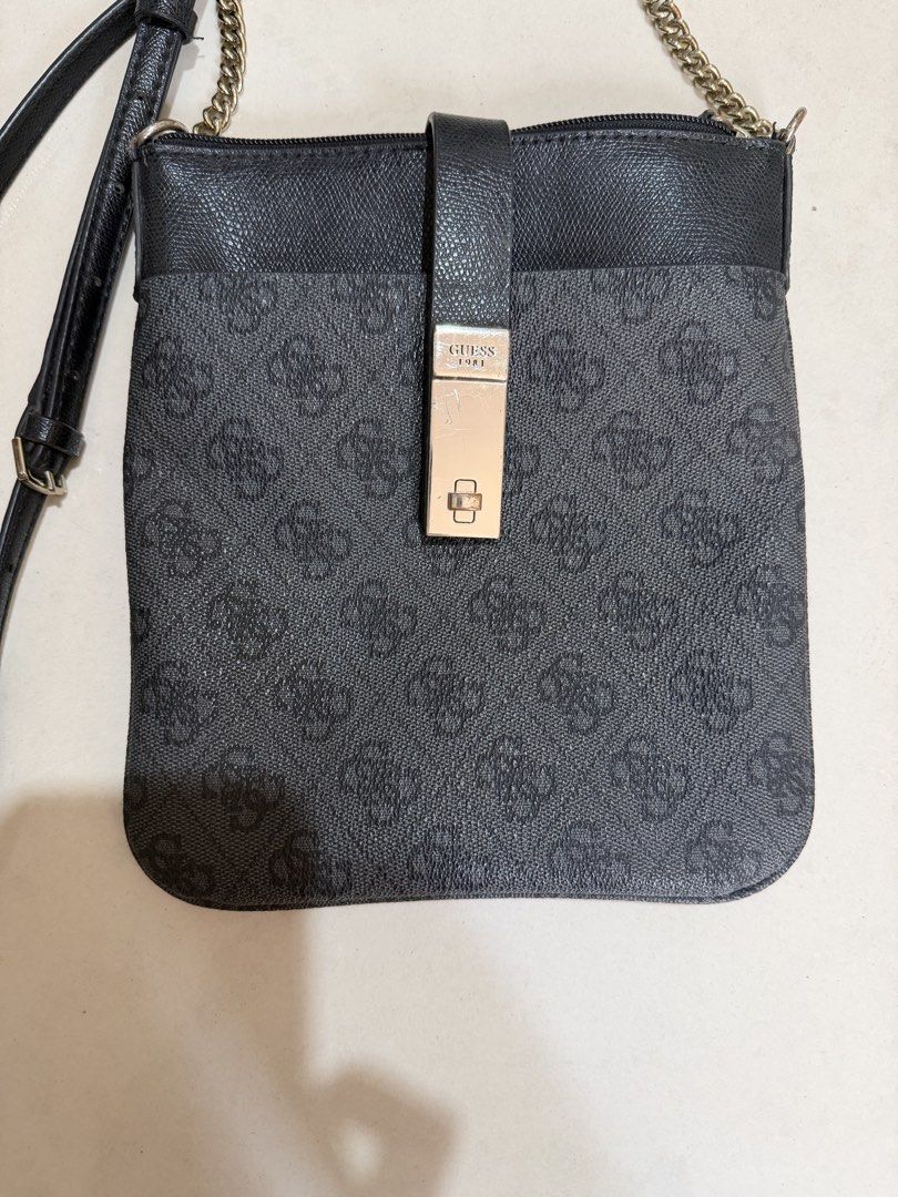 Guess 1981 Monogram Black Crossbody Bag (Category: Cross-body Bags) located in Paranaque City. Submitted by mryjwll (Listing ID 1470177898, Image 2). Description: - Brand: Guess - Style: Crossbody bag in classic black with 1981 monogram pattern - Material: Saffiano leather texture on top panel and front strap - Hardware: Rectangular metallic front clasp with debossed branding and gold-tone chain accent - Strap: Adjustable black faux leather shoul