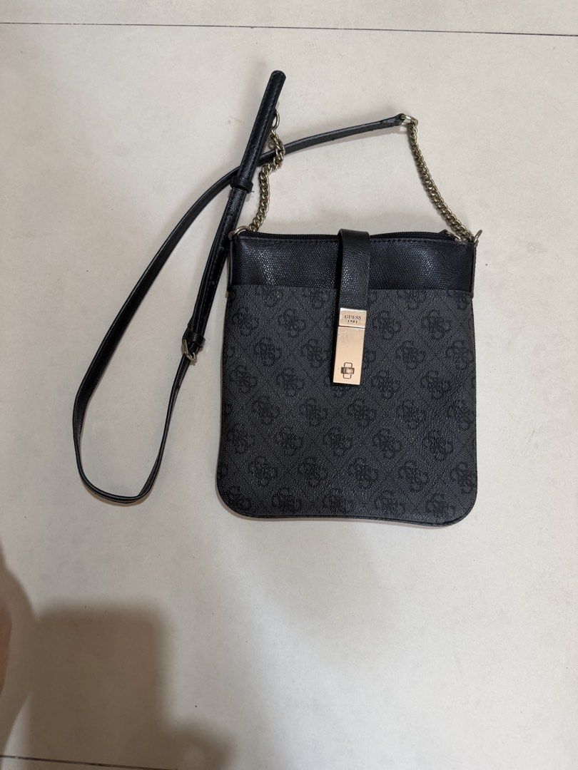 Guess 1981 Monogram Black Crossbody Bag (Category: Cross-body Bags) located in Paranaque City. Submitted by mryjwll (Listing ID 1470177898, Image 1). Description: - Brand: Guess - Style: Crossbody bag in classic black with 1981 monogram pattern - Material: Saffiano leather texture on top panel and front strap - Hardware: Rectangular metallic front clasp with debossed branding and gold-tone chain accent - Strap: Adjustable black faux leather shoul