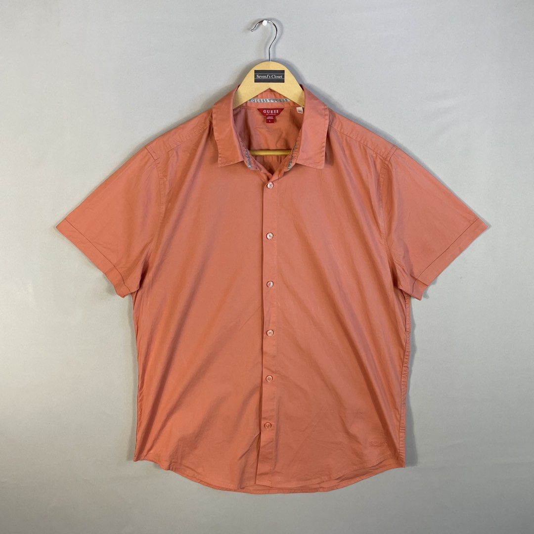 GUESS | Peach Solid Short-Sleeve Button-Down Shirt Size L (Category: Tshirts & Polo Shirts ) located in Norzagaray. Submitted by sevenjscloset (Listing ID 1470273898, Image 1). Description: - Brand: GUESS - Style: Short-sleeve button-down with classic collar - Color: Solid peach - Size: Large on tag - Measurements: 27.5" length x 20.5" width - Fit Reference: Modeled by 5'10" and 70kg individual - Condition: Excellent, no issues or flaws spotted.