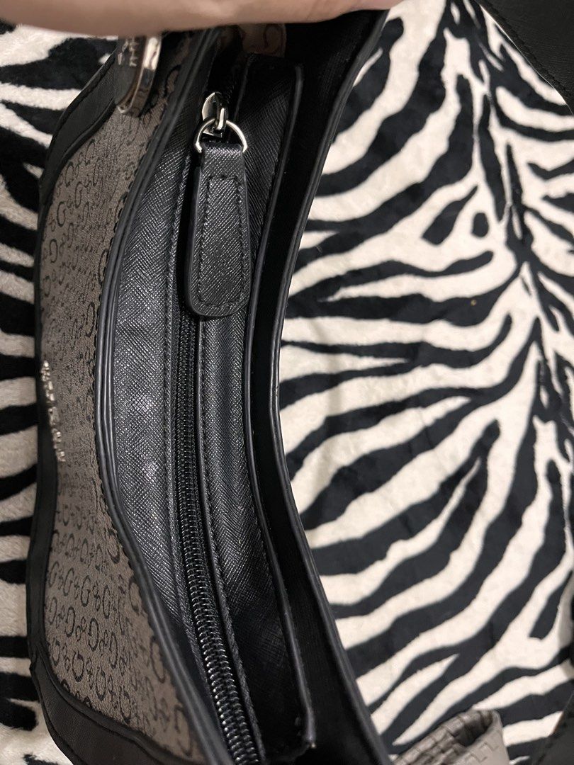 Guess Monogram Black and Grey Shoulder Bag (Category: Shoulder Bags) located in Quezon City. Submitted by pickleballpaddle (Listing ID 1470328822, Image 3). Description: - Brand: Guess - Design: Classic black and grey monogram pattern with faux leather trim - Closure: Secure zip-top closure - Style: Compact curved shape designed to sit comfortably under the arm - Extras: Removable Guess logo charm on the strap base - Interior: Clean lining with a
