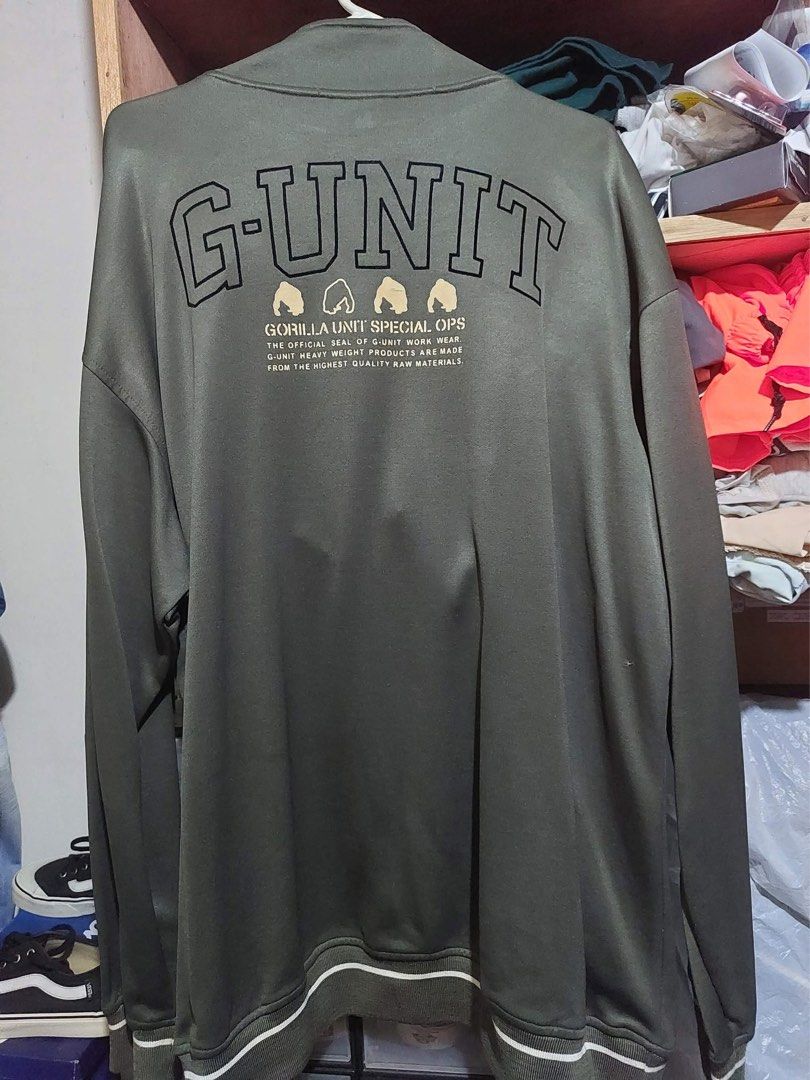 G-Unit Olive Green Full Zip Track Jacket XL (Category: Coats, Jackets and Outerwear) located in Manila. Submitted by yu-jimin (Listing ID 1470198844, Image 2). Description: - Brand: G-Unit - Color: Olive green with white stripe details - Size: Extra Large (XL) - Design: Full zip front, graphic print on back reading 'Gorilla Unit Special Ops', plus smaller chest and side logos - Features: Zippered side pockets, ribbed collar, cuffs, and hem - Cond