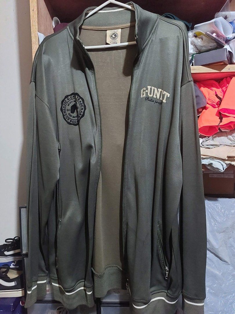 G-Unit Olive Green Full Zip Track Jacket XL (Category: Coats, Jackets and Outerwear) located in Manila. Submitted by yu-jimin (Listing ID 1470198844, Image 1). Description: - Brand: G-Unit - Color: Olive green with white stripe details - Size: Extra Large (XL) - Design: Full zip front, graphic print on back reading 'Gorilla Unit Special Ops', plus smaller chest and side logos - Features: Zippered side pockets, ribbed collar, cuffs, and hem - Cond