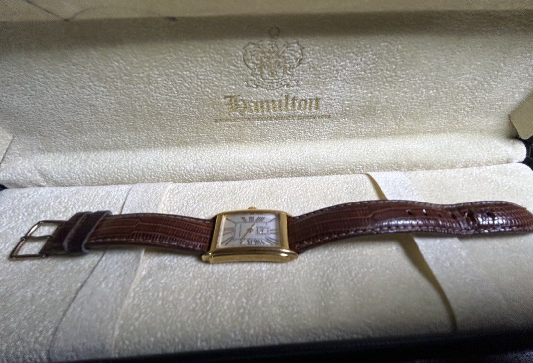 Hamilton rectangular gold dress watch with leather strap (Category: Luxury Watches) located in Manila. Submitted by japanarchivefinds (Listing ID 1470224322, Image 2). Description: - Brand: Hamilton rectangular dress watch - Color: Gold-tone polished case with silver dial and Roman numerals - Features: Small seconds sub-dial at 6 o'clock and battery-operated quartz movement - Strap: Brown lizard grain leather strap with pin buckle - Condition: Cl