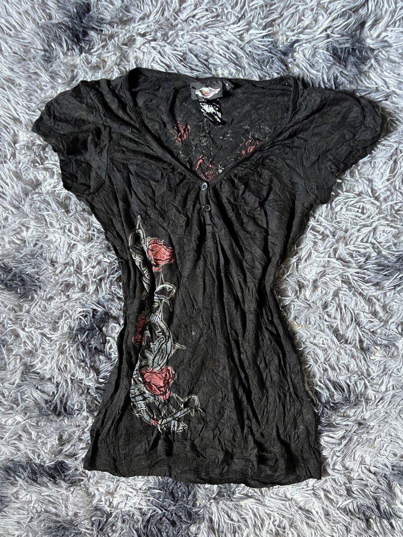 Harley-Davidson Black Rose Wing Graphic Top (Category: Shirts) located in Tarlac. Submitted by zealbird-9188e4 (Listing ID 1470281069, Image 1). Description: - Brand: Harley-Davidson - Style: V-neck top with short cap sleeves, button placket, and crinkle-texture fabric - Size: M - Material: 54% cotton blend - Front Design: Large rose and barbed wire graphic on the left side - Back Design: Massive winged rose graphic with Harley-Davidson banner - 