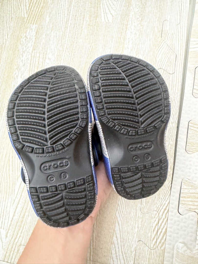 Harry Potter Ravenclaw Crocs Clogs Size C6 (Category: Babies & Kids Fashion) located in Naga. Submitted by suit_yourslf (Listing ID 1470151376, Image 3). Description: - Item: Harry Potter Ravenclaw Crocs Clog Sandals - Size: C6 (indicated on outsole) - Color/Design: Black base with blue heel strap and Ravenclaw lettering - Included Charms: Ravenclaw crest, raven, and house motto badge - Features: Slip-on design and ventilation holes - Condition: 
