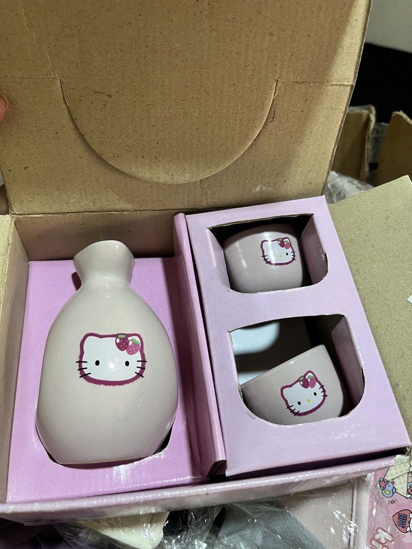 Hello Kitty Ceramic Sake Bottle and Cups Set (Category: Coffee & Tea Tableware) located in Manila. Submitted by janetecson05 (Listing ID 1470157210, Image 1). Description: - Authentic Kitty ceramic sake set - Includes 1 sake bottle and 2 small cups - Soft pinkish grey color with charming graphic and strawberry motif - Brand new, never used, and in pristine condition - Comes complete with original pink cardboard packaging and brown shipping box - 