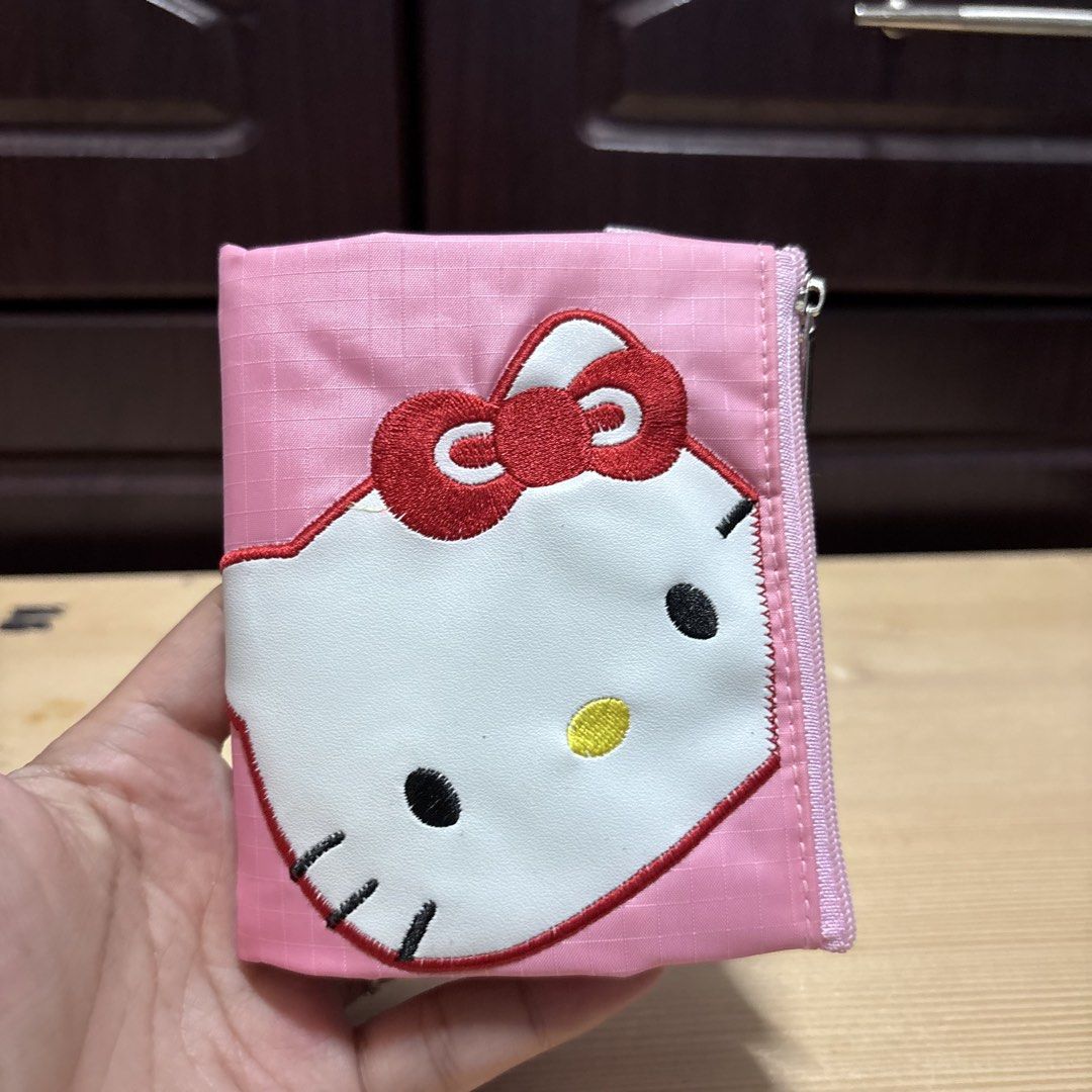 Hello Kitty Pink Tri-fold Wallet with Coin Zipper (Category: Wallets & Card holders) located in Manila. Submitted by nero.ph (Listing ID 1470348424, Image 1). Description: - Super cute pink Kitty tri-fold wallet - Features a large embroidered Kitty face on the front - Clear ID slot for easy access - Convenient red pocket for folded bills - Secure zipper compartment for coins - Trendy grid pattern fabric material - Compact, great everyday size for