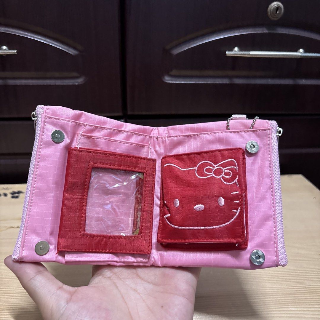 Hello Kitty Pink Tri-fold Wallet with Coin Zipper (Category: Wallets & Card holders) located in Manila. Submitted by nero.ph (Listing ID 1470348424, Image 2). Description: - Super cute pink Kitty tri-fold wallet - Features a large embroidered Kitty face on the front - Clear ID slot for easy access - Convenient red pocket for folded bills - Secure zipper compartment for coins - Trendy grid pattern fabric material - Compact, great everyday size for