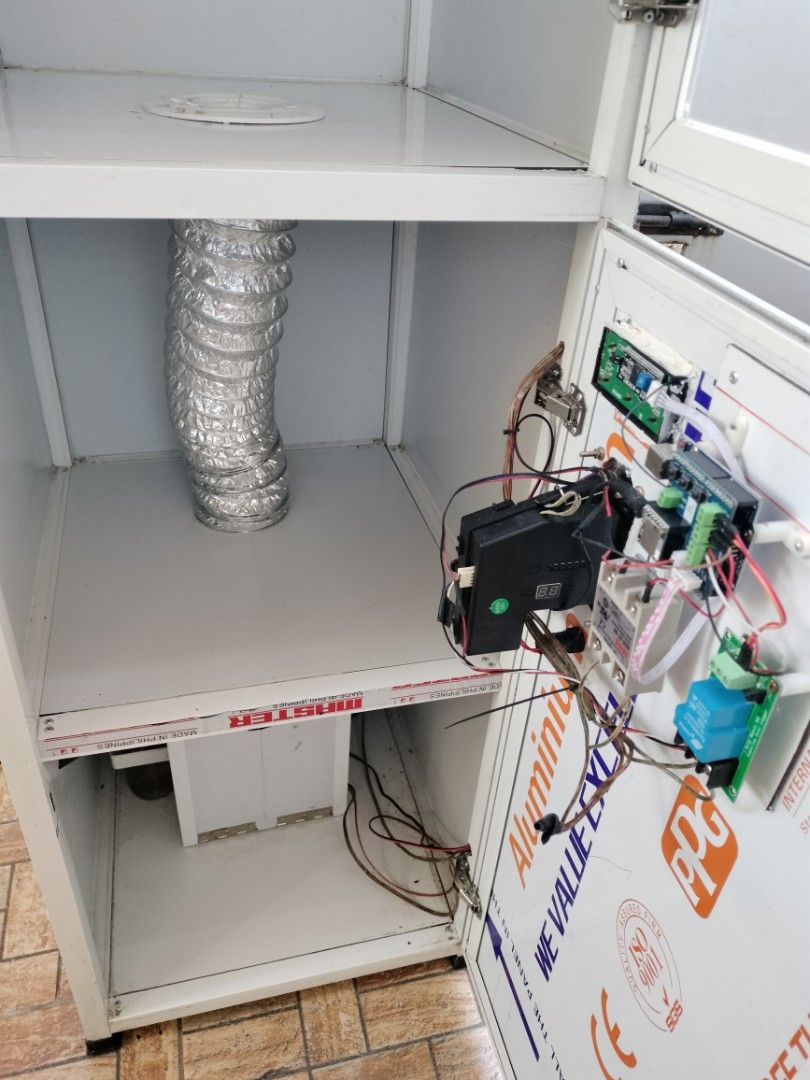 Helmet Vacuum machine (Category: Virtual Reality) located in Bulacan. Submitted by epicriver.0ac812 (Listing ID 1470155258, Image 3). Description: - White aluminum cabinet with glass doors - Lower compartment includes wiring, circuit boards, and digital display - Equipped with internal cooling fa n, ventilation duct, and lighting tubes - Features Master and Honor Home branding stickers - Clean interior with built-in ventilation grilles - Solid co