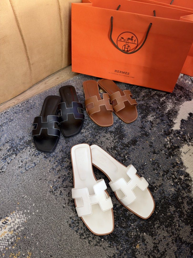 Hermes Oran Sandals (Category: Flats & Sandals) located in Manila. Submitted by luxuryelle88 (Listing ID 1470247419, Image 1). Description: Size 39 Best fit 38/39 - Brand: Hermes Oran Sandals - Colors Available: Black, Brown, and White - Design: Iconic H cutout strap, slip-on style - Sole: Flat leather sole - Condition: Clean leather uppers and smooth inner lining - Inclusion: Orange shopping bag included - Perfect for effortless everyday luxury 