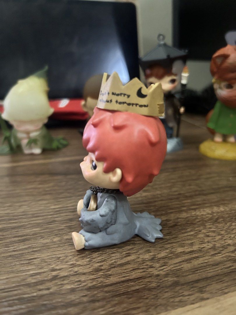 Hirono Shelter (Category: Designer & Blind Box Toys) located in Manila. Submitted by mihos.garage.sale (Listing ID 1470186726, Image 2). Description: - Features striking red hair, a grey outfit, and cute big eyes - Wears a golden crown inscribed with 'Don't worry about tomorrow' and 'Matthew 6:34' - Comes with a mini clock on a metal chain accessory - Collected and displayed carefully on a shelf, smoke-free home.