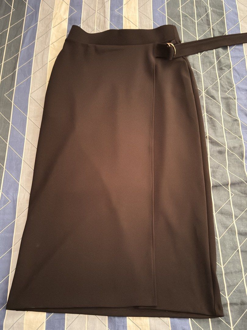 H&M Black Wrap Skirt Size S (Category: Skirts) located in Cavite. Submitted by quickdeer_f75623 (Listing ID 1470166076, Image 3). Description: - Brand: H&M - Size: S (EUR S, US S) - Color: Solid black - Style: Midi length wrap skirt with side belt detail and metal ring closure - Material: Comfortable and stretchy polyester blend - Versatility: Easy to style for office wear or casual outings - Condition: Excellent, no flaws noticed.