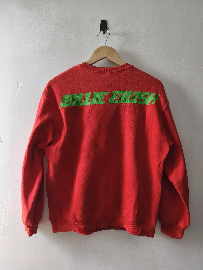 H&M Divided Billie Eilish Red Sweatshirt (Category: Coats, Jackets and Outerwear) located in Manila. Submitted by gelog2 (Listing ID 1470154781, Image 2). Description: - Brand: H&M Divided - Artist: Billie Eilish official merch style - Color: Red with neon green and black accents - Design: Front graphic print with green lettering across the back - Condition: Vibrant colors, no fading - Measurements: 25 inches (length) x 20.5 inches (width).
