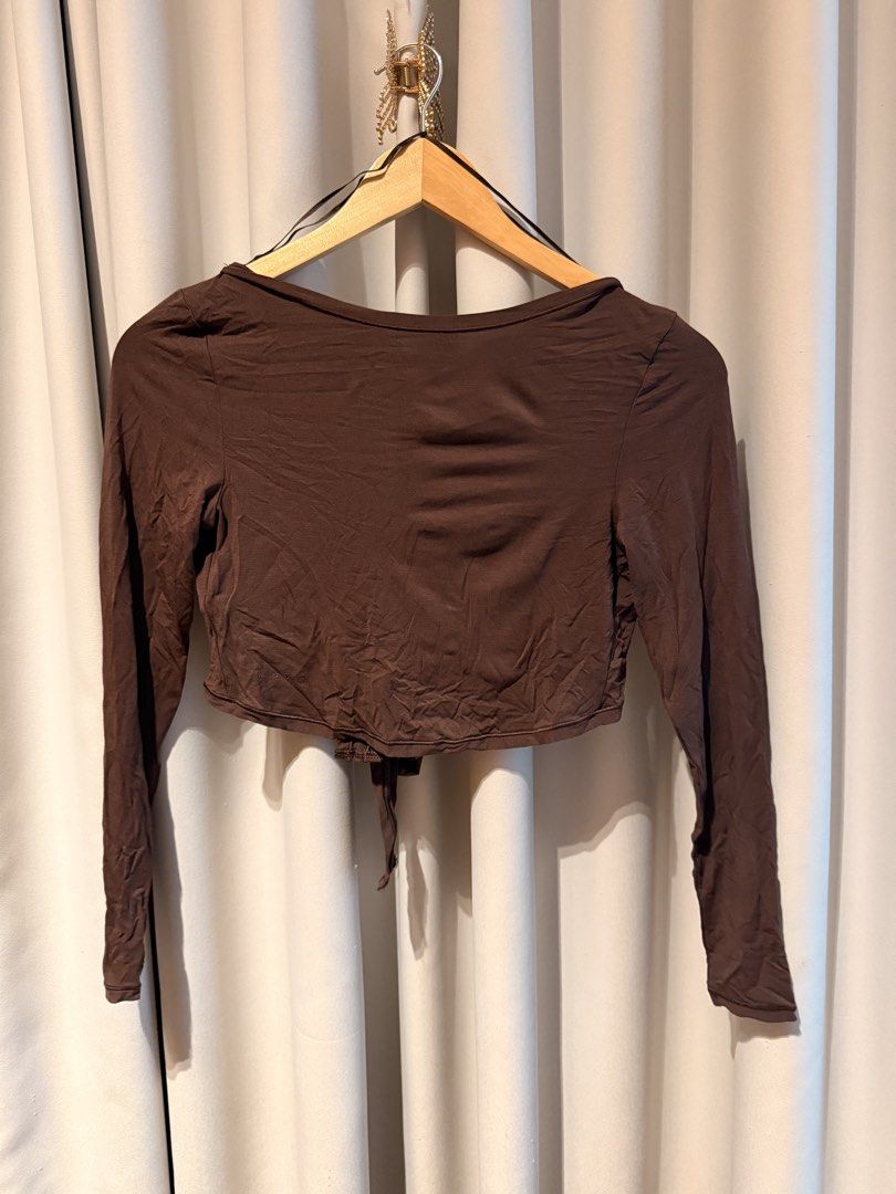 H&M Move Brown Long Sleeve Wrap Front Tie Crop Top (Category: Activewear) located in Makati City. Submitted by regalbbb (Listing ID 1470320264, Image 2). Description: Original Price: Can't remember RFS: Decluttering Condition: No flaws, never used in - Color: Rich brown - Style: Long-sleeve crop top with wrap front and secure center tie - Neckline: Scoop neckline in the back - Material: Smooth and stretchy fabric for all-day comfort - Versatility