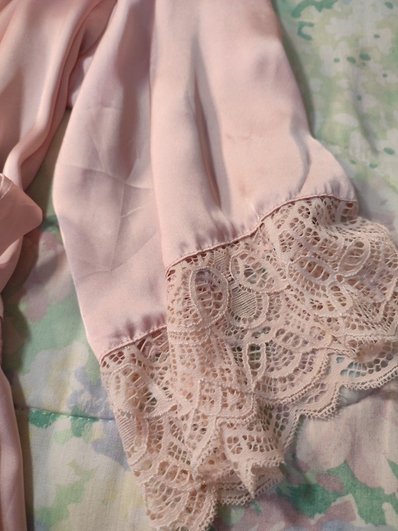 H&M Pink Satin Lace Trim Robe (Category: Undergarments & Loungewear) located in Jaen. Submitted by roxantiago (Listing ID 1470275628, Image 3). Description: - Color: Pink satin with a slight sheen - Design: V-neck wrap style with matching tie belt - Details: Delicate lace trim on sleeves and shoulders - Condition: Gentle wear, great lounging piece can fit up to L flaws: minimal stain and holes. see photos.