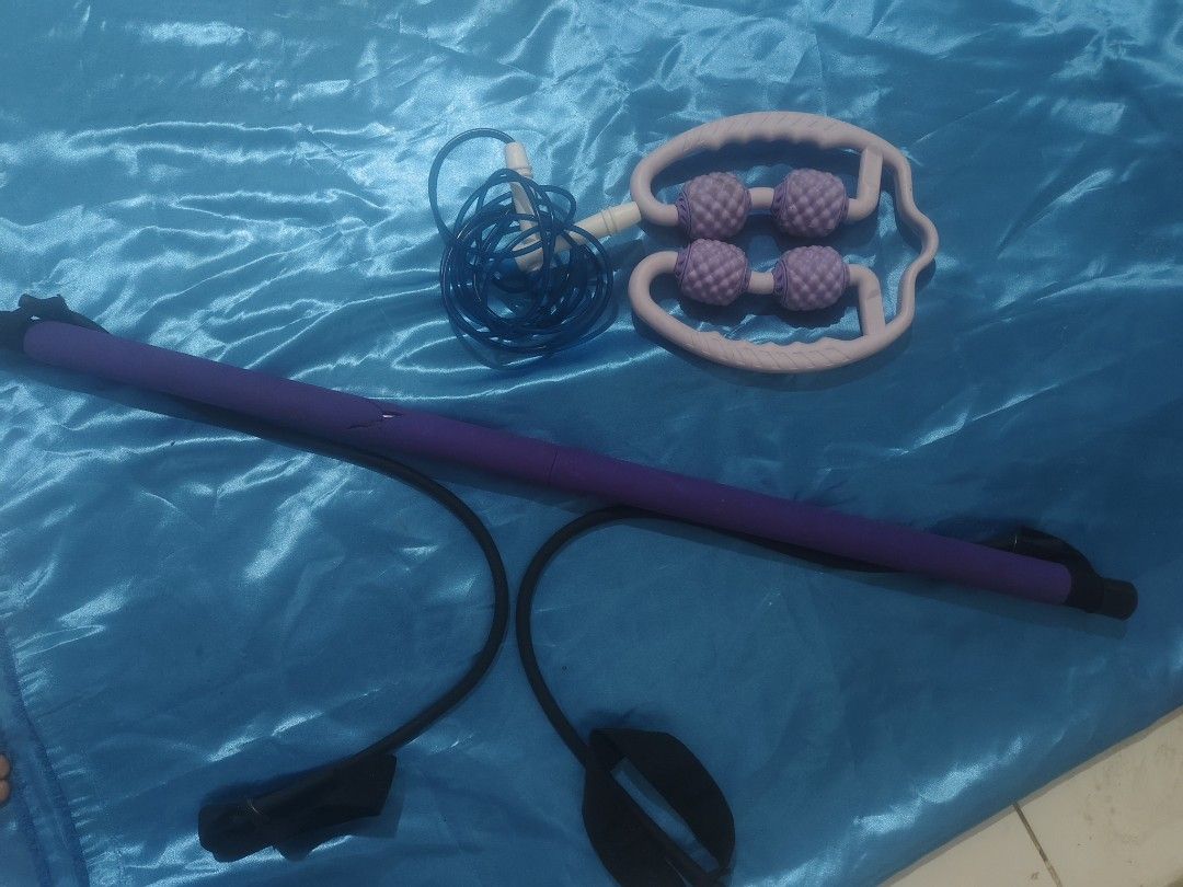 Home Workout Bundle Pilates Bar Roller Skipping Rope (Category: Toning & Stretching Accessories) located in Bulacan. Submitted by babz30261 (Listing ID 1470262355, Image 1). Description: Bundle includes a purple pilates resistance bar with attached black bands, a blue skipping rope, and a purple 4-wheel muscle massage roller. Great set for full body stretching, toning, and recovery at home. Everything packs up easily and takes up minimal space. U