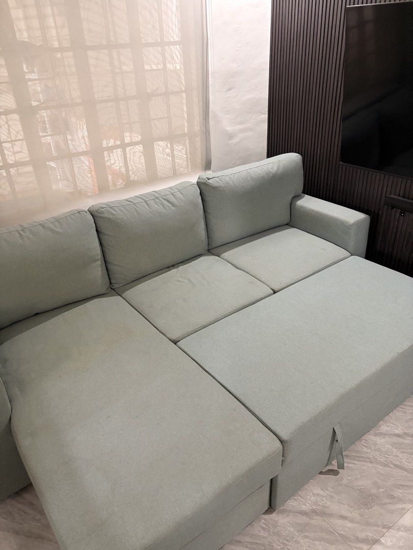 Ikea L-Shaped Sofa Bed (Category: Sofas) located in Taguig. Submitted by jesrm (Listing ID 1470251722, Image 1). Description: - Color: Light sage green - Material: Comfortable fabric upholstery with removable cushions - Features: Built-in pull-out bed Has few stains .