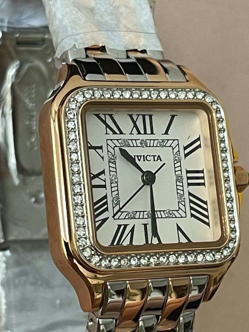 Invicta Square Crystal Roman Numeral Two-Tone Watch (Category: Women's Watches) located in Cavite. Submitted by vastowl_7d1ce5 (Listing ID 1470159669, Image 2). Description: - Brand new with original yellow box and all protective plastics intact - Unique square face design with a sparkling crystal bezel - Classic Roman numeral markers with a chic blue cabochon crown - Stunning two-tone bracelet strap in silver and rose gold - RUSH SALE / PM for i