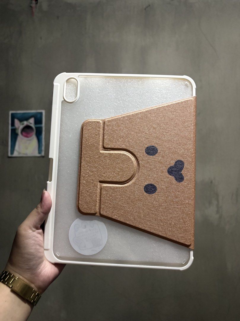 IPAD 10.9in A19 and 10th gen case (Category: Cases & Sleeves) located in Manila. Submitted by royalpengwen (Listing ID 1470306869, Image 2). Description: - Compatible with iPad 10.9-inch (10th Generation) - Cute brown front cover with minimalist character design - Transparent back case adorned with aesthetic stickers - 360-degree rotation support for multi-angle viewing (portrait and landscape) - Sturdy build for everyday protection against scrat