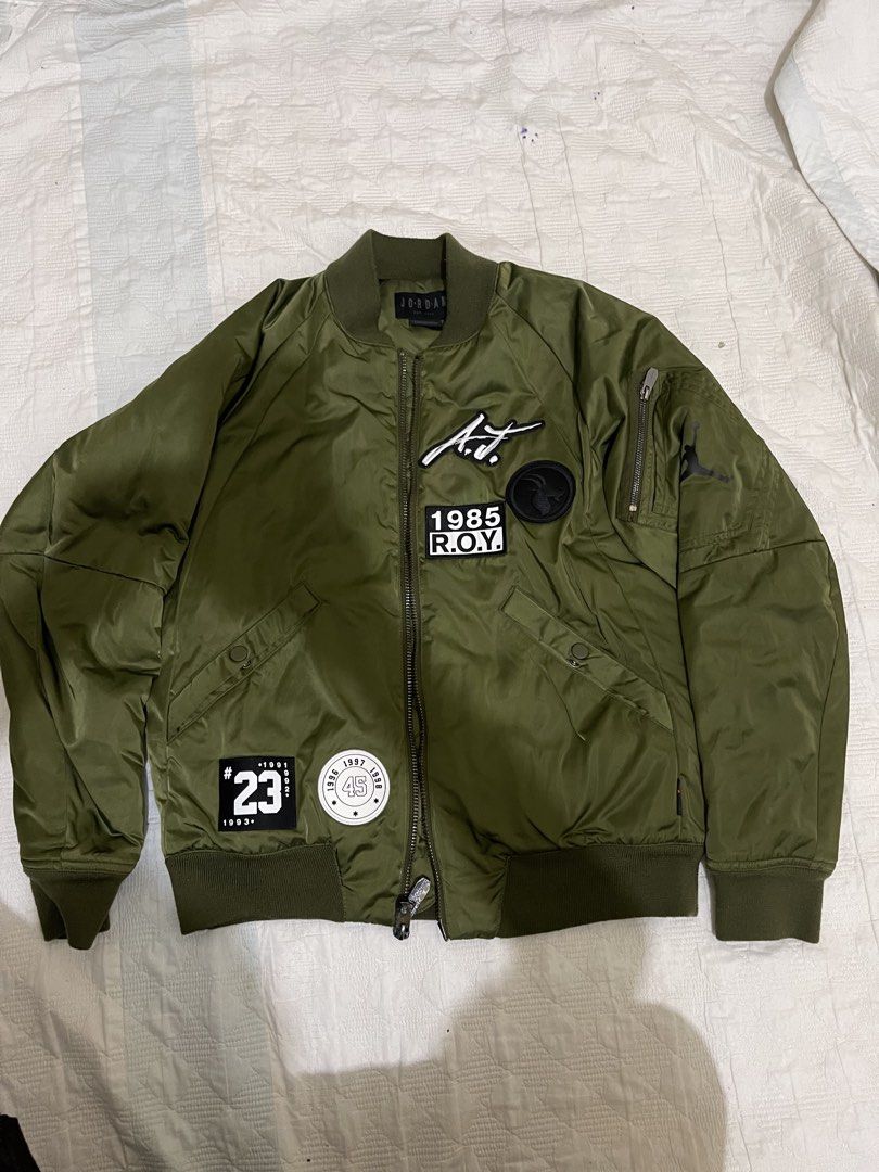 Jordan Olive Green Bomber Jacket Size M (Category: Coats, Jackets and Outerwear) located in Caloocan City. Submitted by noblecat_c04f74 (Listing ID 1470149855, Image 1). Description: - Brand/Model: Jordan bomber jacket - Color: Olive green - Size: Medium - Design: Patches on the front chest and bold text printing on the back - Lining: Quilted black inner lining for extra comfort - Details: Ribbed collar, cuffs, and hem with a full zip closure and