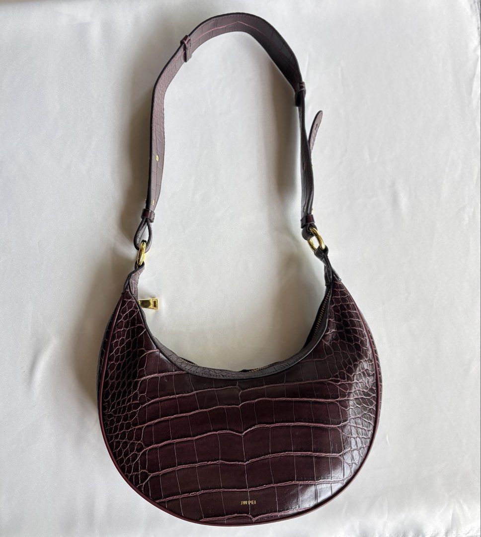 JW PEl Carly Saddle Bag (Category: Shoulder Bags) located in Iloilo. Submitted by iconicangie (Listing ID 1470309426, Image 1). Description: - Brand: JW PEI - Style: Crescent shoulder bag / half-moon shape - Color / Material: Dark burgundy, croc-embossed leather - Hardware: Gold tone - Closure & Strap: Secure zip closure with an adjustable strap - Condition: Brand new with tag attached (includes serial number H0D9-302-1-03-0733) - Capacity: Fits 