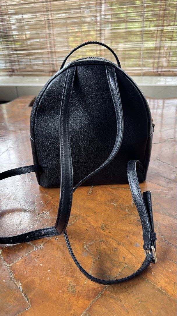 Kate Spade New York Black Leather Backpack (Category: Backpacks) located in Tagbilaran City. Submitted by Bunnybebu (Listing ID 1470295810, Image 2). Description: - Brand: Kate Spade New York - Material: Luxurious black pebble leather with gold hardware - Exterior: Front zip pocket with pull tab and signature spade logo plaque - Interior: Signature wordmark patterned fabric lining with an extra zip pocket and slip pockets - Straps: Convenient top