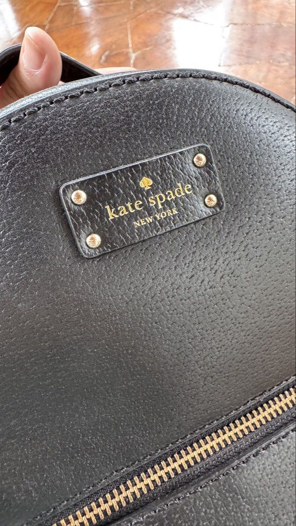 Kate Spade New York Black Leather Backpack (Category: Backpacks) located in Tagbilaran City. Submitted by Bunnybebu (Listing ID 1470295810, Image 3). Description: - Brand: Kate Spade New York - Material: Luxurious black pebble leather with gold hardware - Exterior: Front zip pocket with pull tab and signature spade logo plaque - Interior: Signature wordmark patterned fabric lining with an extra zip pocket and slip pockets - Straps: Convenient top