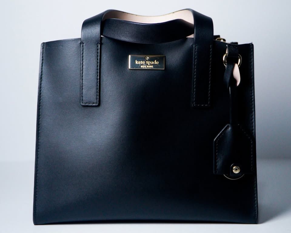 Kate Spade Putnam Drive Anissa (Category: Luxury Bags & Wallets) located in Caloocan City. Submitted by jnlchvz0612 (Listing ID 1468995247, Image 1). Description: - Brand: Kate Spade - Model: Putnam Drive Small Nelle - Color: Classic Black - Material: Premium Leather - Hardware: Gold (with stamped front flap lettering) - Style: Structured tote with top handles and charm tag detail - Interior: Features a convenient zip pocket - Inclusions: Origina