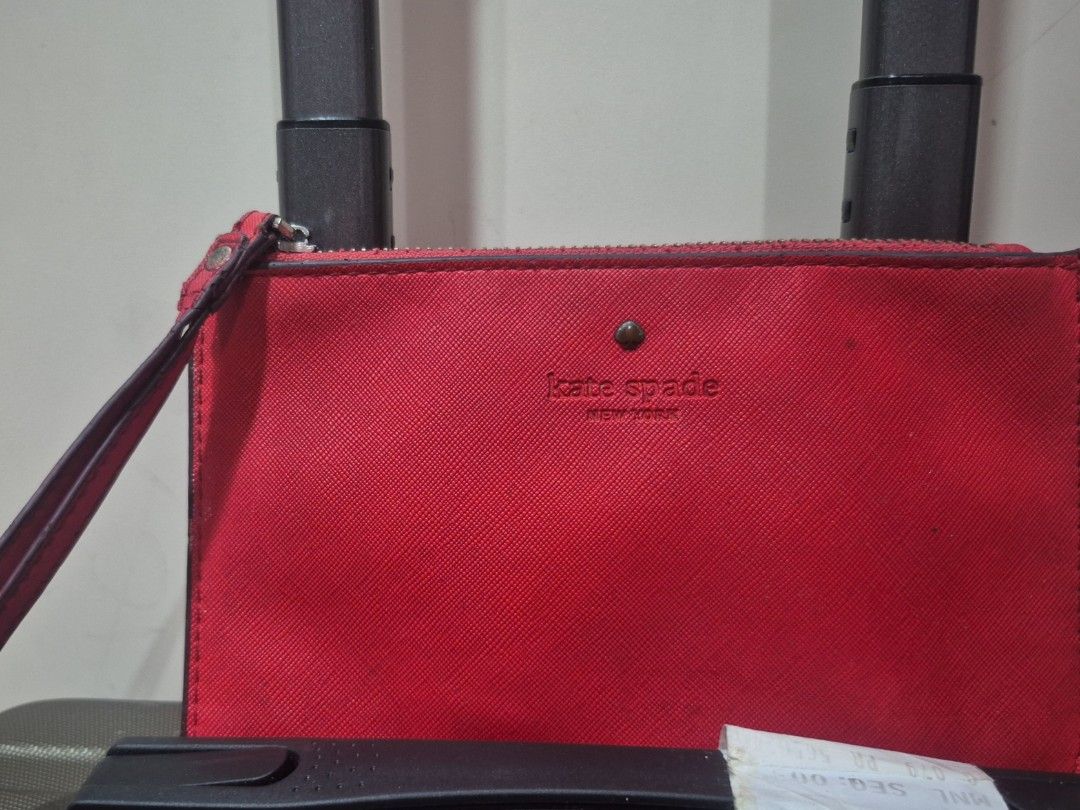 Kate Spade Red Wristlet Pouch (Category: Purses & Pouches) located in Iloilo. Submitted by gorgeoustatz (Listing ID 1470282677, Image 1). Description: - Brand: Kate Spade - Material: Premium red Saffiano leather - Hardware: Elegant gold-tone zipper closure - Interior: Chic beige and brown polka dot fabric lining - Features: Attached wrist strap and debossed front brand logo - Size: Compact and convenient for cards, cash, and small essentials - Re