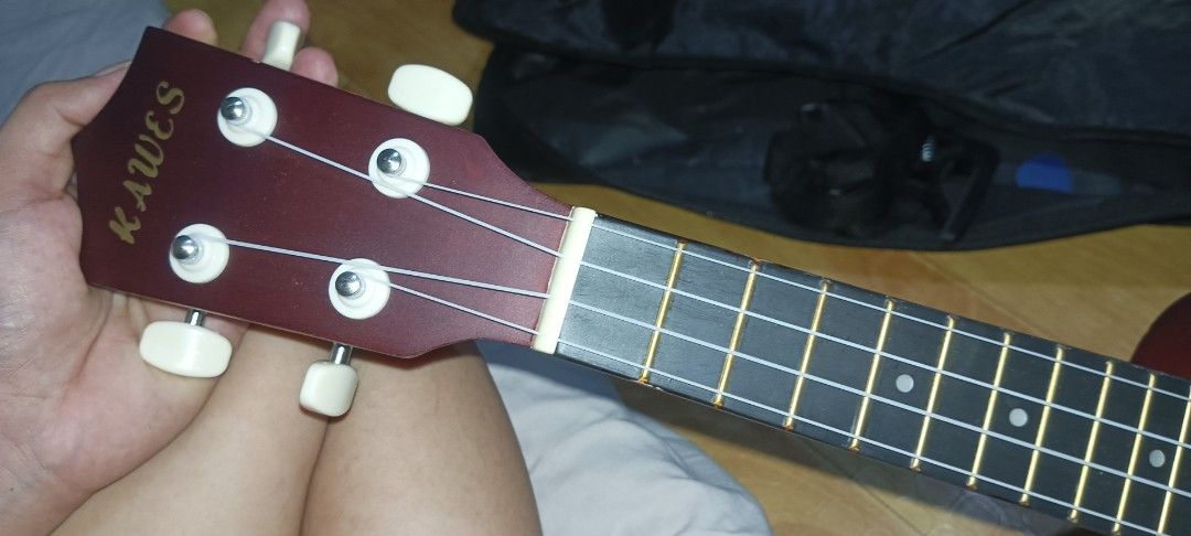 Kawes Ukulele bundle with tuner and picks (Category: Musical Instruments) located in Manila. Submitted by maryros_1996 (Listing ID 1470210809, Image 3). Description: - Kawes acoustic ukulele with a stunning natural wood finish and dark reddish-brown back and sides - Standard fretboard featuring white dot markers and easy-on-the-fingers nylon strings - Includes a black clip-on digital tuner for accurate and quick tuning - Comes with a set of color
