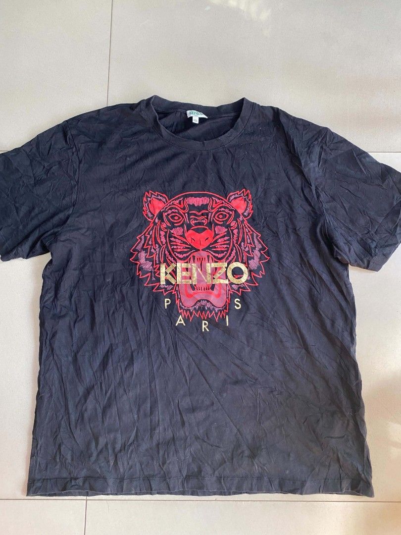 Kenzo Tiger Graphic Black T-Shirt (Category: Tshirts & Polo Shirts ) located in Manila. Submitted by nadyrl (Listing ID 1470307701, Image 1). Description: - Brand: Kenzo - Color: Black - Size: XXL (Relaxed casual fit) - Material: 100% Cotton - Design: Large red and gold tiger graphic print with Paris branding - Neckline: Crew neck - Origin: Made in Portugal - Style Code: F855TS0504Y7.