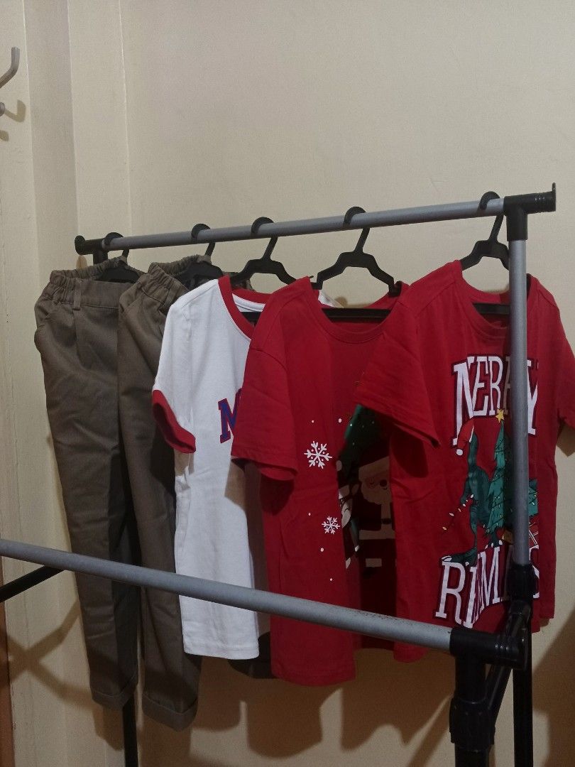 Kids Bundle Mossimo Shirt Christmas Tees Pants (Category: Babies & Kids Fashion) located in Lapu Lapu. Submitted by dawatkrist14304 (Listing ID 1470297020, Image 1). Description: - 5-piece kids' clothing bundle - 1x White Mossimo New York ringer tee - 2x Red holiday shirts with festive Christmas graphics - 2× Brown trousers with a comfortable elastic waistband - Condition: Clean fabrics, neatly stored on hangers - Perfect mix for everyday casual 