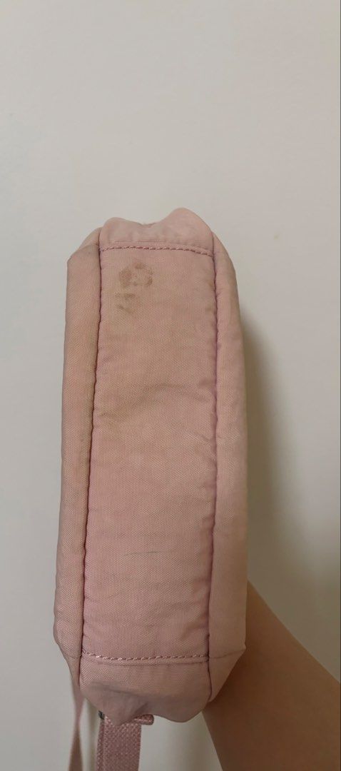 Kipling Pink Nylon Crossbody Bag (Category: Cross-body Bags) located in Angeles City. Submitted by chaegyoung (Listing ID 1470240779, Image 3). Description: - Authentic Kipling crossbody bag in a charming light pink shade - Durable nylon material with an adjustable shoulder strap for comfort - Secure zipper top closure opening to a spacious lined interior - Signature round Kipling logo patch on the front - Flaw note: Some dirt marks and stains ar